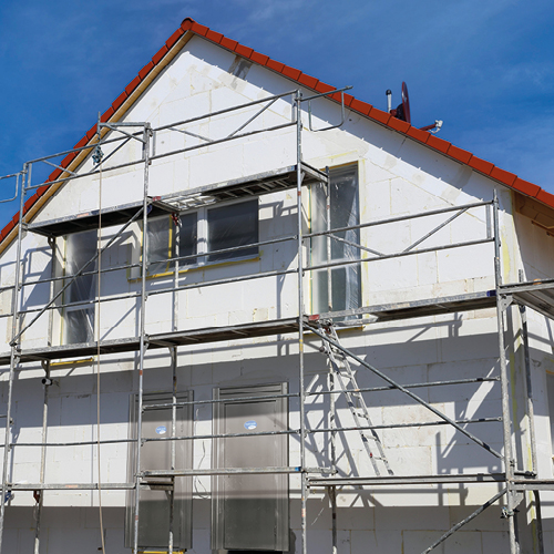 Eine Baustellenschutztür von steinau hinter einem Gerüst